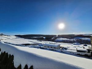 霍姆弗斯Cozy rural lodge, amazing views close to Holmfirth的一片雪地,太阳照耀下