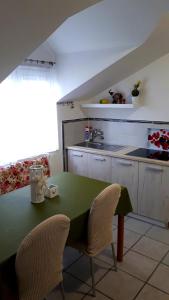 比耶拉Apartmani Kalinic的厨房配有绿色的桌子和两把椅子