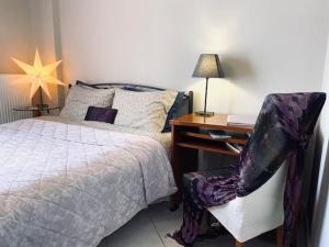 特里波利斯Central Charming Apartment的一间卧室配有一张床、一张桌子和一把椅子