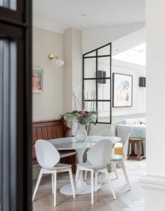 伦敦ALTIDO Spectacular house with private garden的白色的用餐室配有桌子和白色的椅子