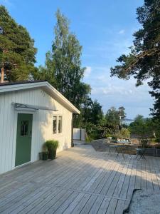 Årsta HavsbadModern cottage in Årsta Havsbad Stockholm, Sweden的木制甲板,设有建筑和庭院