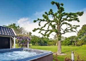 OeffeltGuesthouse de Heide的院子里的树,带热水浴缸