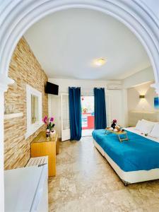 阿齐欧斯·贡多斯Romantic Palace Beach Apartments的一间设有蓝色床和蓝色窗帘的大卧室