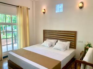 达瓦拉维Imperial Resort的一间卧室配有一张带白色床单的床和一扇窗户。