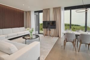 萨武德里亚Petram Resort & Residences的客厅配有白色的沙发和桌子