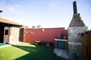 桑坦德Casa independiente con chimena, jardín y barbacoa的后院设有石制壁炉和长凳