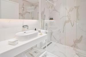 萨武德里亚Petram Resort & Residences的白色的浴室设有水槽和淋浴。