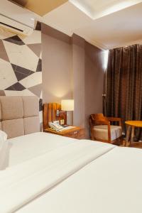 坦噶Tanga Beach Resort & Spa的配有一张床和一把椅子的酒店客房