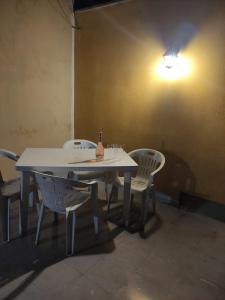 莫杜尼奥Affittacamere Girasole的一张白色的桌子和椅子,上面有一瓶葡萄酒