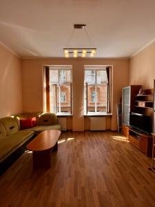 利沃夫Apartaments near Ploshcha Rynok的带沙发和桌子的客厅以及2扇窗户。