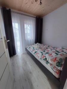 萨比诺瓦Domki Letniskowe Family Dreams的一间卧室配有一张带床罩的床和窗户