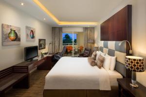 阿布扎比Metropolitan Al Mafraq Hotel的酒店客房设有一张大床和一台电视。