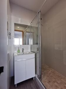 卡帕里卡海岸Vila Alexandra的白色的浴室设有水槽和淋浴。