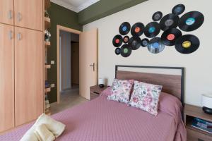里科索翁Aurelia Apartment的卧室配有一张床铺,墙上有一堆记录