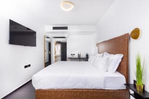 纳哈里亚מלון בוטיק H34的卧室配有白色的床和电视