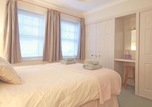 巴姆博格No 9 Armstrong Cottage的卧室配有白色床和毛巾