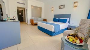 沙姆沙伊赫Club Reef Resort & Spa的酒店客房,配有一张床和一碗水果放在桌子上