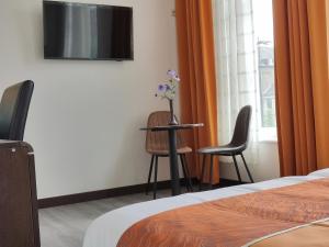 阿纳姆CN-Hotel的酒店客房配有桌子、两把椅子和电视。