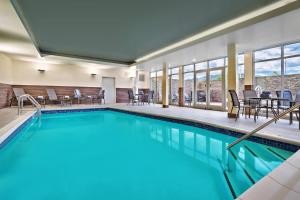 利文斯顿Fairfield Inn & Suites by Marriott Livingston Yellowstone的酒店客房的游泳池配有桌椅