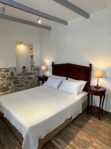 锡米西娅酒店的一间卧室配有一张大床、两张桌子和两盏灯。