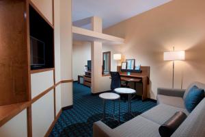 查尔斯顿北查尔斯顿/大学区费尔菲尔德套房酒店的带沙发和书桌的酒店客房