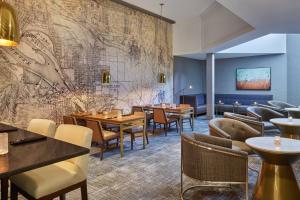 波特兰波特兰机场喜来登酒店 的一间设有桌椅的餐厅,墙上有地图
