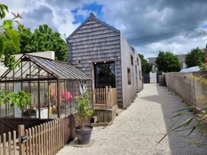 昂热Tiny House Cosy 2 - Angers Green Lodge的谷仓改建,设有温室和房屋