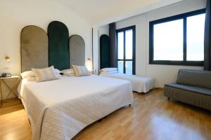 普拉托米兰艺术酒店的酒店客房,配有两张床和椅子
