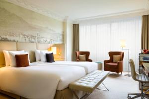 卢塞恩卢塞恩万丽酒店的酒店客房带一张大床和椅子