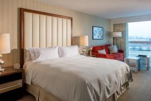 伊丽莎白纽瓦克机场万丽酒店的酒店客房设有一张大床和一张红色椅子。