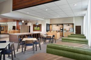 弗莱彻Fairfield Inn & Suites by Marriott Asheville Airport/Fletcher的一间设有绿色家具和桌椅的餐厅