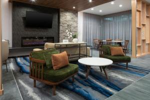麦金尼Fairfield by Marriott Inn & Suites Dallas McKinney的客厅配有两把椅子和壁炉