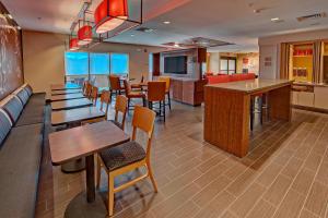 哈蒂斯堡TownePlace Suites by Marriott Hattiesburg的一间带桌椅的餐厅和一间酒吧