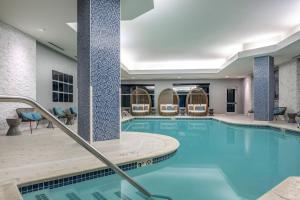 福克斯伯勒波士顿爱国者中心万丽酒店的一座酒店游泳池周围设有椅子