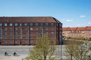 哥本哈根Moxy Copenhagen Sydhavnen的两人骑车在砖砌建筑前