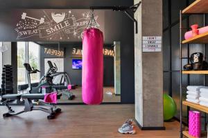 哥本哈根Moxy Copenhagen Sydhavnen的健身房,带一个粉红色的冲泡袋的健身房
