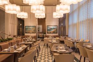 迈阿密迈阿密布杂艺术酒店的用餐室配有桌椅和吊灯。