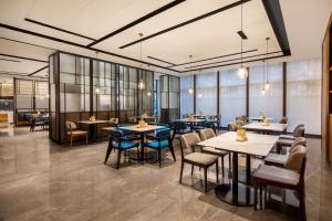 杭州杭州萧山万枫酒店的餐厅设有桌椅和窗户。