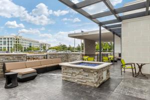 夏洛特SpringHill Suites Charlotte Southwest的庭院设有热水浴池、桌子和椅子。