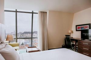 瓜亚基尔瓜亚基尔万豪酒店的酒店客房设有一张床和一个大窗户