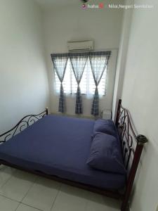 汝来Homestay Nilai D'Jati的一间卧室配有一张蓝色的床和窗户