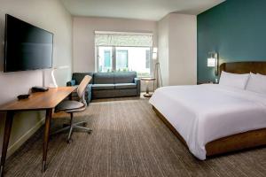 汉普顿Element Hampton Peninsula Town Center的一间酒店客房,一间设有一张床和一张书桌