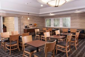退休小镇群村唐普雷斯套房酒店的用餐室配有木桌和椅子