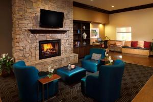 休斯顿休斯顿洲际机场万豪广场套房酒店的客厅配有蓝色椅子和壁炉