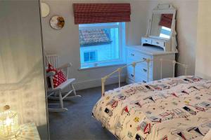 法利Lilly’s Cottage, Filey, Sleeps 8的一间卧室设有一张床、一个窗口和一面镜子