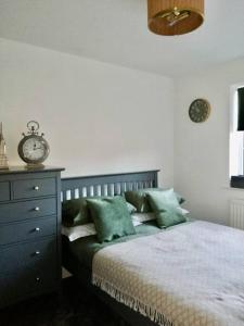 赫尔Cottage/boutique style - Free parking & Wi-Fi的一间卧室配有一张床、梳妆台和时钟