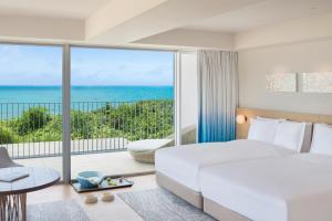 宫古岛IRAPH SUI, a Luxury Collection Hotel, Miyako Okinawa的一间卧室配有一张床,享有海景