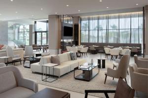 蓬塔卡纳AC Hotel by Marriott Punta Cana的酒店大堂设有沙发和桌椅