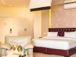 安曼安曼西部酒店的配有一张床和一把椅子的酒店客房