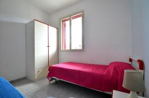 新福卡Trilocale Ll05 a 200m dal mare的一间卧室设有红色的床和窗户。